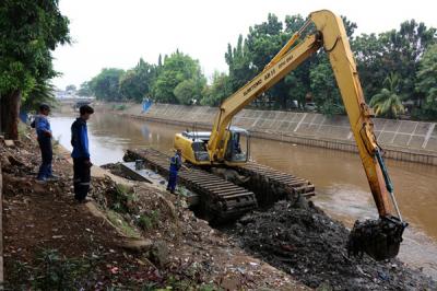 Petugas Dinas SDA Provinsi DKI Jakarta menggunakan alat berat saat mengeruk lumpur di aliran sungai Ciliwung, kampung Melayu, Jakarta, Senin (4/10/2021).