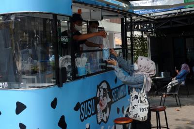 Pembeli Susu Sedunia melakukan pembayaran secara digital atas gerobak UMKM di kawasan Bendungan Hilir, Jakarta Pusat, Minggu (3/10/2021).