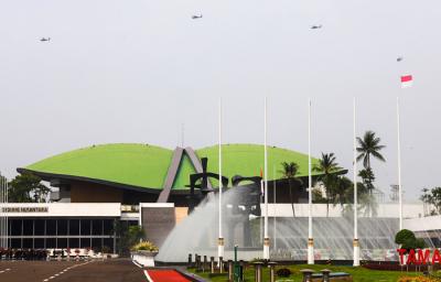 Helikopter TNI terbang dengan mengibarkan bendera Merah Putih dan Lambang TNI melintas di atas gedung nusantara, Jakarta, Selasa (5/10/2021).
