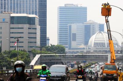 Petugas saat memperbaiki lampu penerangan di Jalan Gatot Subroto, Jakarta Selatan, Selasa (5/10/2021).