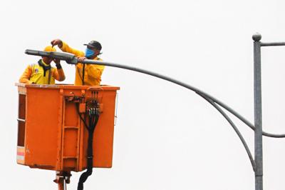 Petugas saat memperbaiki lampu penerangan di Jalan Gatot Subroto, Jakarta Selatan, Selasa (5/10/2021).