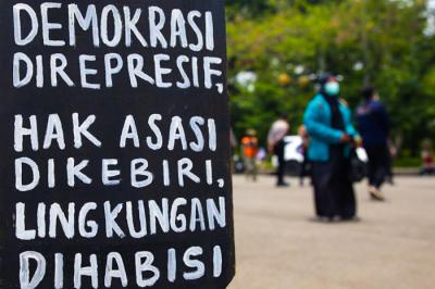 Mahasiswa membentangkan poster saat melakukan aksi unjuk rasa di kawasan Monas, Jakarta, Rabu, (6/10/2021).