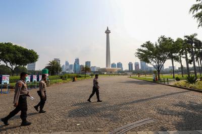 Pengunjung dan sejumlah petugas pengamanan saat berada di kawasan Monas, Jakarta Pusat, Kamis (7/10/2021).