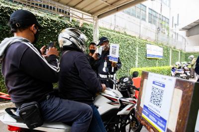 Pekerja melakukan pindai QR code melalui aplikasi PeduliLindungi di kawasan perkantoran Kebon Jeruk, Jakarta Barat, Jumat (8/10/2021).