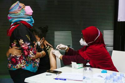 Vaksinator menyuntikkan vaksin Covid-19 jenis Pfizer kepada warga di Sentra Vaksinasi Dosis 2 MNC Peduli, MNC Center, Jakarta Pusat, Senin (11/10/2021).