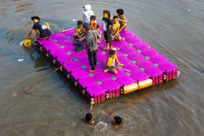 Anak-anak saat bermain menggunakan perahu gabus di Kali Ciliwung, Jakarta Pusat, Selasa (12/10/2021).