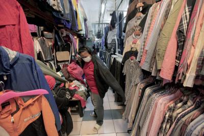 Pedagang sedang melayani calon pembeli pakaian bekas yang di jual di Pasar Senen, Jakarta, Kamis (14/10/2021).