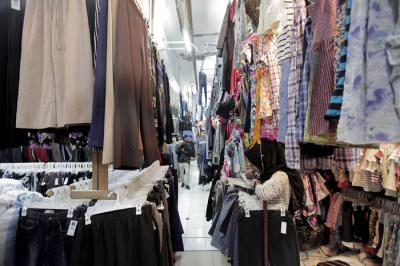 Pedagang sedang melayani calon pembeli pakaian bekas yang di jual di Pasar Senen, Jakarta, Kamis (14/10/2021).