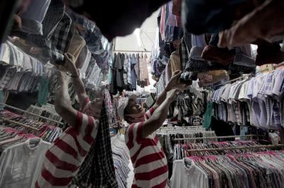 Pedagang sedang melayani calon pembeli pakaian bekas yang di jual di Pasar Senen, Jakarta, Kamis (14/10/2021).