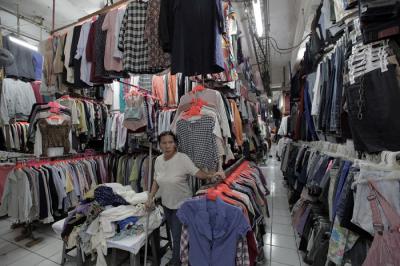 Pedagang sedang melayani calon pembeli pakaian bekas yang di jual di Pasar Senen, Jakarta, Kamis (14/10/2021).