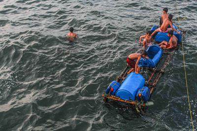 Sejumlah anak-anak sedang berenang di dermaga kapal nelayan, Cilincing, Jakarta Utara, Jumat (15/10/2021).