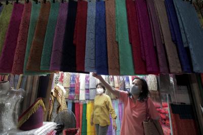 Calon pembeli memilih kain ulos yang dijual di Pasar Senen, Jakarta Pusat, Jumat (15/10/2021).