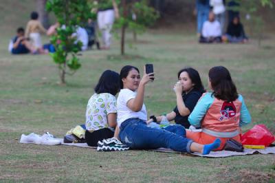 Warga menikmati suasana menjelang sore di Hutan Kota GBK Jakarta, Minggu (17/10/2021).