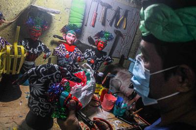 Masudi atau Bang Ntong Salam membuat miniatur Ondel-ondel di toko miliknya di kawasan Pondok Kopi, Kecamatan Duren Sawit, Jakarta Timur, Senin (18/10/2021).