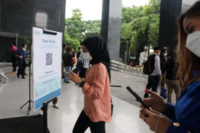 Para pengunjung dan pegawai melakukan scan identitas melalui aplikasi PeduliLindungi saat akan memasuki gedung PN Jakarta Pusat, Selasa (19/10/2021).