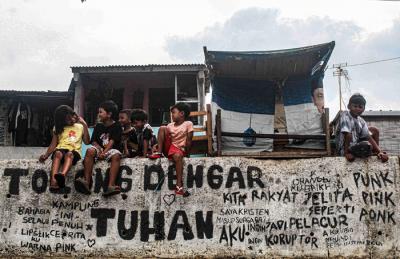 Anak-anak sedang bermain tanpa menggunakan masker di tepi sungai, Jakarta, Selasa (19/10/2021).
