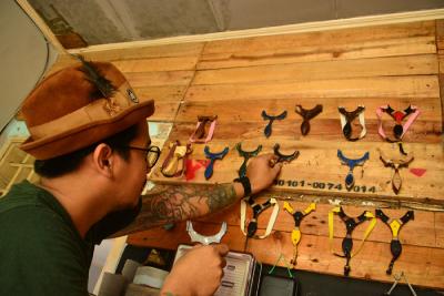 Seorang pengrajin ketapel (slingshot) menyelesaikan pembuatan ketapel di Workshop Depok, Jawa Barat, Rabu (20/10/2021).