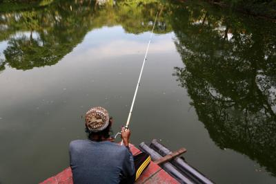 Warga memancing di Danau Taman Kebun Bibit Wonorejo Surabaya, Jawa Timur, Jumat (22/10/2021).