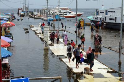 Warga pengguna jasa transportasi ojeg atau perahu tradisional Penyeberangan kepulauan seribu tiba di Pelabuhan Kali Adem Muara Angke, Sabtu (23/10/2021).