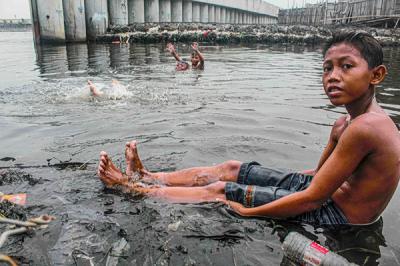 Sejumlah anak-anak sedang bermain di dermaga yang dikelilingi sampah di kawasan Cilincing, Jakarta Utara, Senin (25/10/2021).