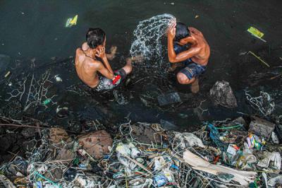 Sejumlah anak-anak sedang bermain di dermaga yang dikelilingi sampah di kawasan Cilincing, Jakarta Utara, Senin (25/10/2021).