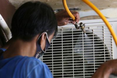 Teknisi membersihkan Air conditioner (AC) disalah satu rumah pelanggan di Surabaya, Jawa Timur, Senin (25/10/2021).