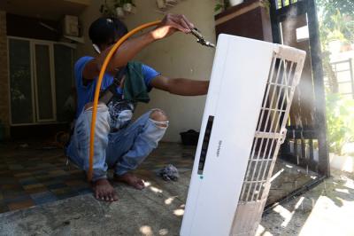Teknisi membersihkan Air conditioner (AC) disalah satu rumah pelanggan di Surabaya, Jawa Timur, Senin (25/10/2021).