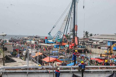 Sejumlah pekerja sedang membangun tanggul pengaman pantai atau National Capital Integrated Coastal Development di Jakarta Utara, Selasa (26/10/2021).