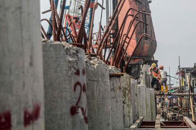 Sejumlah pekerja sedang membangun tanggul pengaman pantai atau National Capital Integrated Coastal Development di Jakarta Utara, Selasa (26/10/2021).