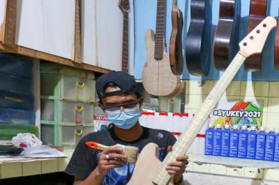 Pekerja menyelesaikan pembuatan gitar listrik Syukey Instrumen di kawasan Ciputat Timur, Tangerang Selatan, Banten, Selasa (26/10/2021).