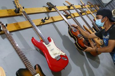 Pekerja menyelesaikan pembuatan gitar listrik Syukey Instrumen di kawasan Ciputat Timur, Tangerang Selatan, Banten, Selasa (26/10/2021).
