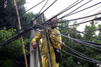 Petugas Dinas Bina Marga DKI Jakarta menata instalasi kabel yang semrawut di kawasan Wolter Monginsidi, Jakarta Selatan, Rabu, (27/10/2021).