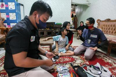 Relawan MNC Peduli memasangkan alat bantu dengar (ABD) untuk Fadli (9) yang mengalami gangguan pendengaran di Kebon Pala, Jakarta Timur, Jumat (29/10/2021).