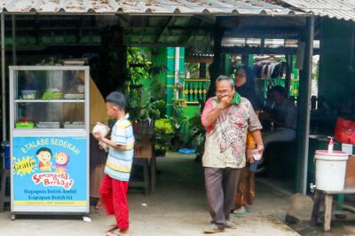 Relawan Yayasan Nasi Jumat (SiJum) Indonesia mengajak warga untuk menikmati makan siang di Warung Makan Gratis, Depok, Jawa Barat, Jumat (29/10/2021).