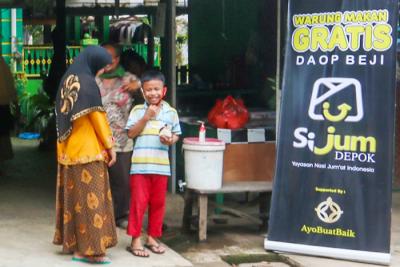 Relawan Yayasan Nasi Jumat (SiJum) Indonesia mengajak warga untuk menikmati makan siang di Warung Makan Gratis, Depok, Jawa Barat, Jumat (29/10/2021).