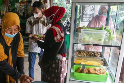 Relawan Yayasan Nasi Jumat (SiJum) Indonesia mengajak warga untuk menikmati makan siang di Warung Makan Gratis, Depok, Jawa Barat, Jumat (29/10/2021).