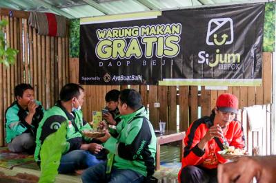 Relawan Yayasan Nasi Jumat (SiJum) Indonesia mengajak warga untuk menikmati makan siang di Warung Makan Gratis, Depok, Jawa Barat, Jumat (29/10/2021).