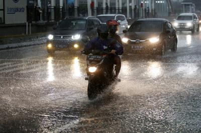 Warga berjalan sambil membawa payung saat hujan di kawasan Bundaran Hotel Indonesia, Jakarta, Senin (1/11/2021).