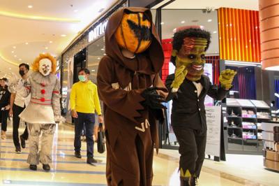 Orang berkostum Halloween berkeliling dan berfoto bersama para pengunjung di Mall Central Park, Jakarta, Minggu (31/10/2021).
