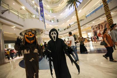 Orang berkostum Halloween berkeliling dan berfoto bersama para pengunjung di Mall Central Park, Jakarta, Minggu (31/10/2021).