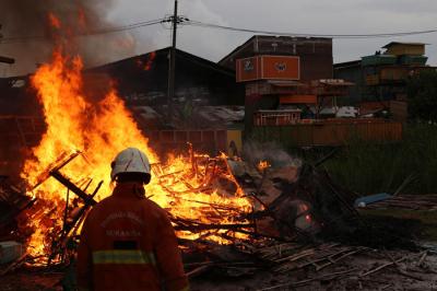 Petugas membakar pagpon atau kandang merpati ketika melakukan penertiban di kawasan Ploso, Tambaksari Surabaya, Jawa Timur, Senin (1/11/2021).