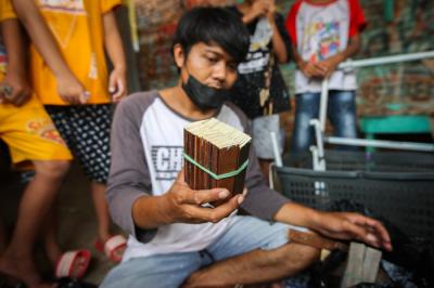 Aris (30) menyelesaikan kerajinan mainan dari limbah kayu di kawasam Pinang Ranti, Jakarta, Minggu (31/10/2021).