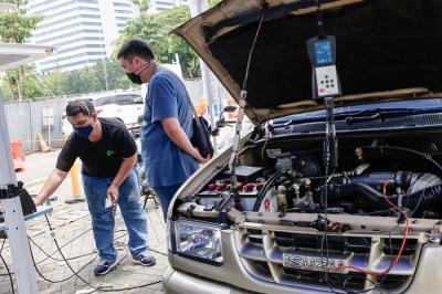 Petugas melakukan uji emisi gas buang kendaraan milik warga di Lapangan Parkir IRTI Monas, Jakarta Pusat, Senin (1/11/2021).