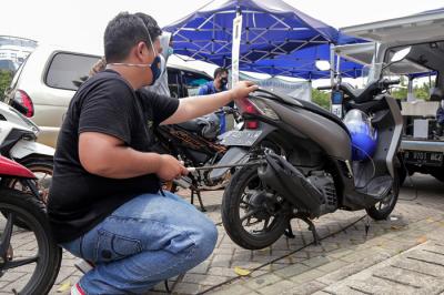 Petugas melakukan uji emisi gas buang kendaraan milik warga di Lapangan Parkir IRTI Monas, Jakarta Pusat, Senin (1/11/2021).