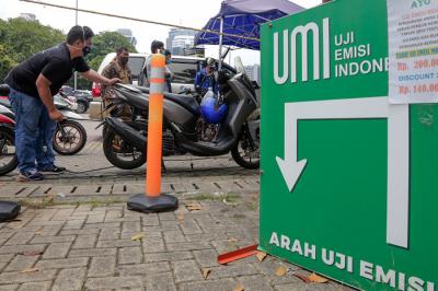 Petugas melakukan uji emisi gas buang kendaraan milik warga di Lapangan Parkir IRTI Monas, Jakarta Pusat, Senin (1/11/2021).