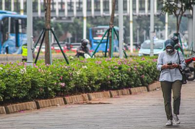Warga melakukan aktivitas sembari menggunakan ponsel di Jakarta, Senin (1/11/2021).