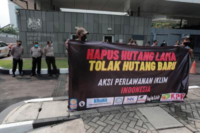 Aktivis melakukan aksi protes ketidakadilan iklim dengan membawa spanduk di depan Kedutaan Besar Inggris, Jakarta, Rabu (3/11/2021).