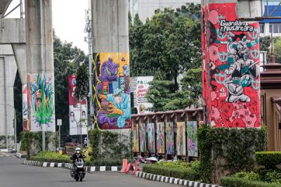 Kendaraan melintas di dekat tiang Jalan Layang Non Tol Transjakarta yang dihiasi mural di kawasan lapangan Bhayangkara, Mabes Polri, Jakarta, Rabu (3/11/2021).