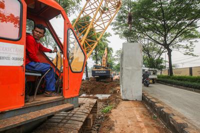 Petugas menyelesaikan pembangunan saluran air di Jalan Gusti Ngurah Rai, Klender, Jakarta Timur, Kamis (4/11/2021).