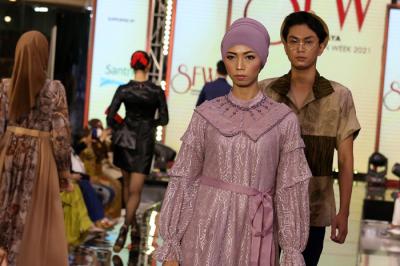 Model memperagakan fashion karya sejumlah desainer dipanggung Surabaya Fashion Week 2021, di Atrium Utama Grand City Mall Surabaya, Jumat (5/11/2021).
